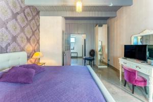 a purple bedroom with a purple bed and a desk at Côté Cour in Rasteau