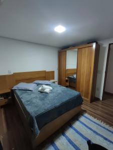 - une chambre avec un lit et un chat assis sur un tapis dans l'établissement Aconchegante Apartamento Charme Mineiro, à Ouro Preto