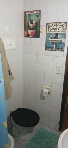 a bathroom with a toilet and a poster of a cat in a sink at Chalet La Gran Familia in San Bernardo +11 photos