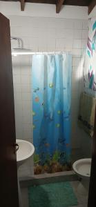 a bathroom with an aquarium shower curtain with a toilet at Chalet La Gran Familia in San Bernardo