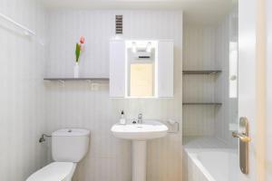a white bathroom with a toilet and a sink at Apartment Zeus in Calpe +18 photos