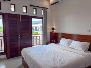 une chambre avec un grand lit et un balcon dans l'établissement San Villa Canggu - 3BR Private Pool & Fast Wifi, à Dalung 25 autres photos