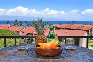 a bowl of fruit on a table with a bottle of champagne at Kaanapali Shores 836 · KS 836 Spacious Studio Kaanapali Oceanfro in Kahana