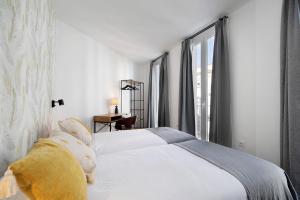 a white dog laying on a bed in a bedroom at Casa Milano 1 in Jerez de la Frontera