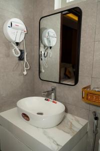 Plei KhưnにあるThảo Ngân Pleiku Hotelの白い洗面台と鏡のあるバスルーム