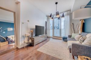 a living room with a couch and a tv at Modern 2 BR Condo - By Scotiabank Arena - City View in Toronto