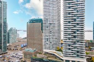 a large tall building in a city with cars at Modern 2 BR Condo - By Scotiabank Arena - City View in Toronto