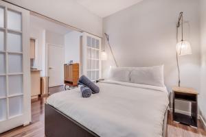 a bedroom with a large white bed with two pillows at Modern 2 BR Condo - By Scotiabank Arena - City View in Toronto