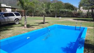a blue swimming pool in a yard with a van at La Elena in La Rioja