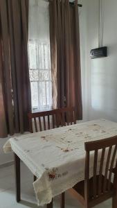 a table with two chairs and a window at Aristar D'Permatang Homestay 4 mu5lim in Bandar  Pusat Jengka