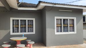 a table and stools in front of a house at Aristar D'Permatang Homestay 4 mu5lim in Bandar  Pusat Jengka