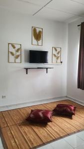 a room with a wooden floor with a flat screen tv at Aristar D'Permatang Homestay 4 mu5lim in Bandar  Pusat Jengka +6 photos
