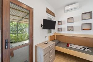 a room with a bed and a tv and a window at Dependance Villa Matteo in Porto Columbu - Perdʼe Sali