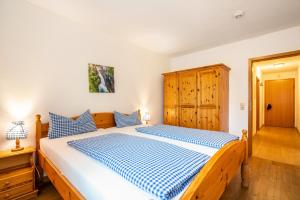 a bedroom with a wooden bed with blue and white sheets at Fewo Brünnstein - Nr 18 Pool, Sauna in Oberaudorf