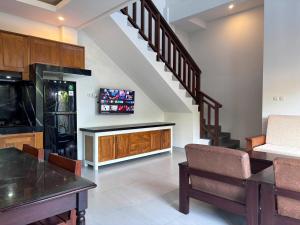 Il comprend un salon avec un escalier et une télévision. dans l'établissement San Villa Canggu - 3BR Private Pool & Fast Wifi, à Dalung