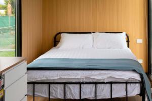 uma cama num pequeno quarto com uma estrutura de cama em Okuti Cottage by Tiny Away em Wairau Valley