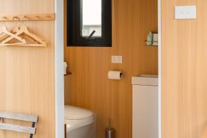 um banheiro com vaso sanitário e janela em Okuti Cottage by Tiny Away em Wairau Valley mais 11 fotografias