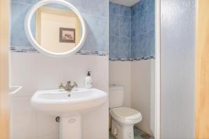 a bathroom with a sink and a toilet and a mirror at Piso Ana Paula 1 in Conil de la Frontera +11 photos
