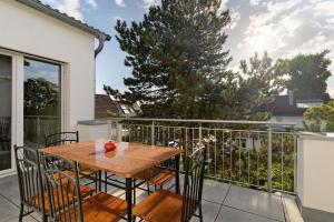 a wooden table and chairs on a balcony at White House Apartments in Kappel-Grafenhausen