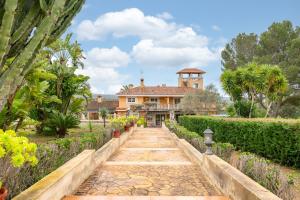a walkway leading to a house in a garden at Casa Alegria in Pòrtol