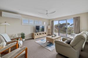 ein Wohnzimmer mit Sofa und Fernseher in der Unterkunft Casa del Mar Phillip Island Ocean Views in Surf Beach