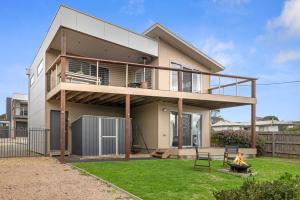 ein Haus mit einer Terrasse und einer Feuerstelle in der Unterkunft Casa del Mar Phillip Island Ocean Views in Surf Beach