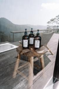 three bottles of wine sitting on a wooden table at Batur Cabins in Kintamani