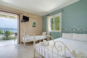 um quarto com uma cama branca e uma varanda em Giorgio studios-apartments 1 em Nikiana