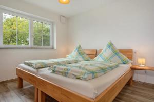 a bedroom with a bed and two windows at Bergsuite in Friedrichshafen