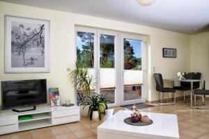 una sala de estar con un televisor y una mesa en Apartment Kessy, en Fuhlendorf