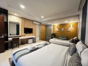 クラビタウンにあるザ ニース クラビ ホテルのベッド2台とテレビがあるホテルの部屋