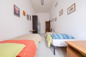 a bedroom with two beds and a table and a desk at Casa Via Medici in Milazzo
