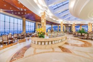 a large lobby with tables and chairs and windows at Avatar Valley Grand Hotel in Zhangjiajie