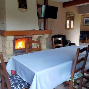 Un comedor con mesa y chimenea. en Gite De La Fermette Aubepines, en Rentières