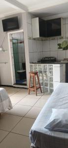 a room with a kitchen with a bed and a stool at Vera's Apart-Hotel & Restaurante in Belém