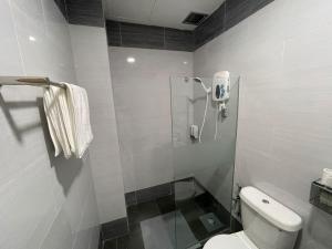 a bathroom with a shower and a toilet at Hotel Benoni in Papar