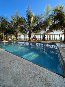 een zwembad met palmbomen op de achtergrond bij Artola Beach Rentals Advisors in La Boquita