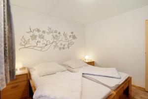 a bedroom with two beds and a wall with a flower mural at Bungalow 14 - Finnhütte in Quitzdorf