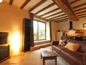 a living room with a leather couch and a window at Charmant duplex avec terrasse, animaux acceptés, WiFi inclus - FR-1-497-163 in Colombiers