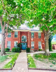 a red brick building with a blue door at Pickleball , Pool , Bkyd Oasis , Centrally Located in Frisco