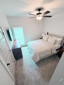 a bedroom with a bed and a ceiling fan at Auburn, Opelika Sleeps 8, close Auburn University in Opelika