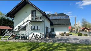 une maison blanche avec des vélos garés devant dans l'établissement Ferienwohnung Spreewald, à Schlepzig
