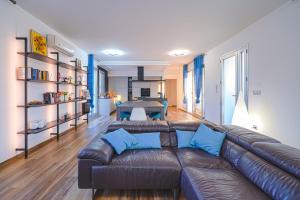 a living room with a leather couch and a table at Villa Opulentia piscine vista mare in Plemmirio
