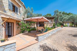 a house with a patio with an umbrella at Dos Villas in Sóller