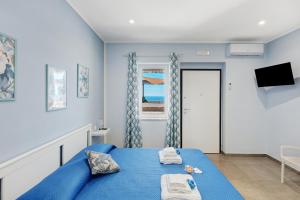 a blue bedroom with a blue bed and a window at La Fiesta House in Capaccio-Paestum