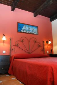 a red bedroom with a red bed and a window at Hotel Encinar Bungalows-Restaurante in Pedro Muñoz
