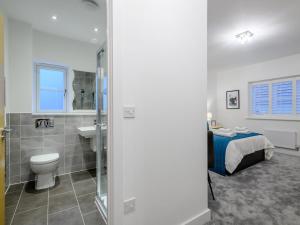 a bathroom with a toilet sink and a bed at 4 Bed in Holt 79034 in Holt +38 photos