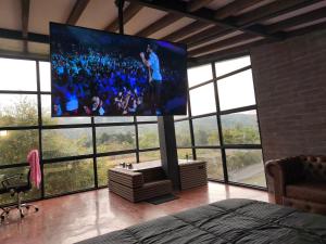 a room with a large tv in a room with windows at Medellin cerca al aeropuerto Rionegro Antioquia in Rionegro