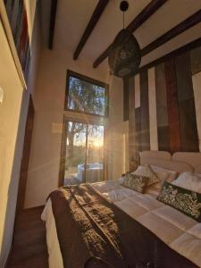 a bedroom with a large bed with a window at Lodge para parejas con jacuzzi hidromasaje in Panguipulli