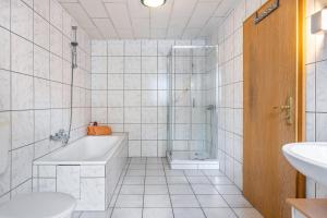 une salle de bain avec une baignoire, une douche et un lavabo dans l'établissement Monteurwohnung Schulze, à Bad Bodenteich 9 autres photos